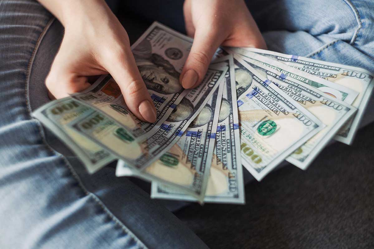 woman holding US bills in her hands