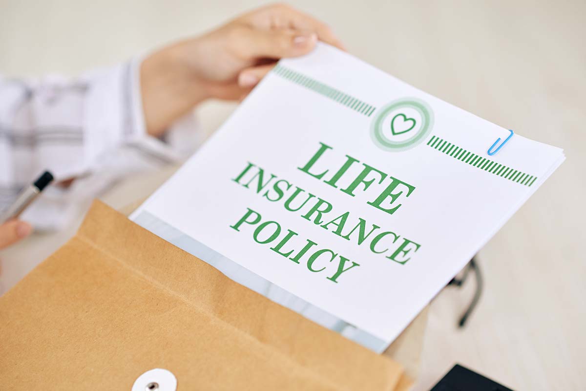 woman taking life insurance policy out of envelope