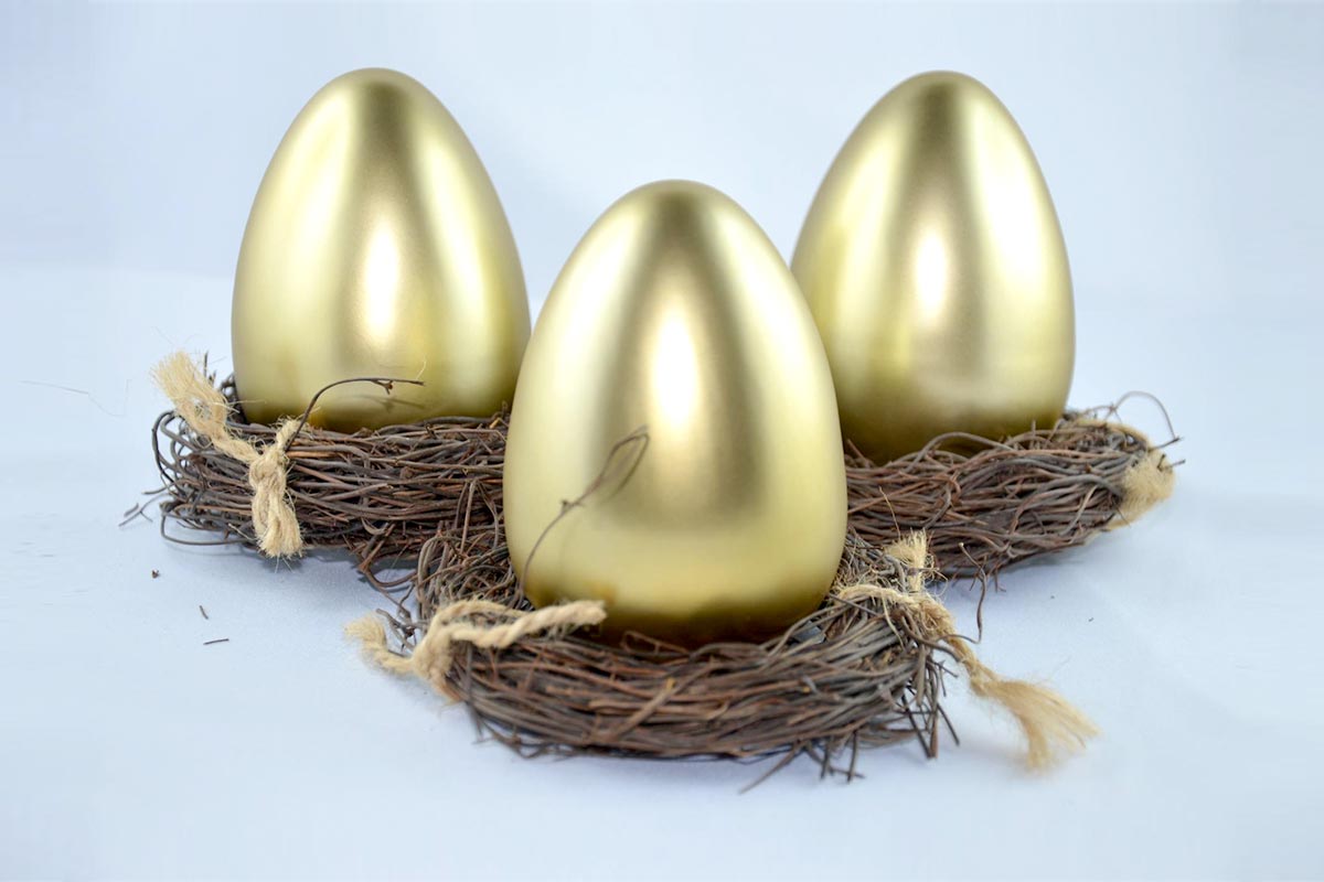 three golden eggs sitting on nests