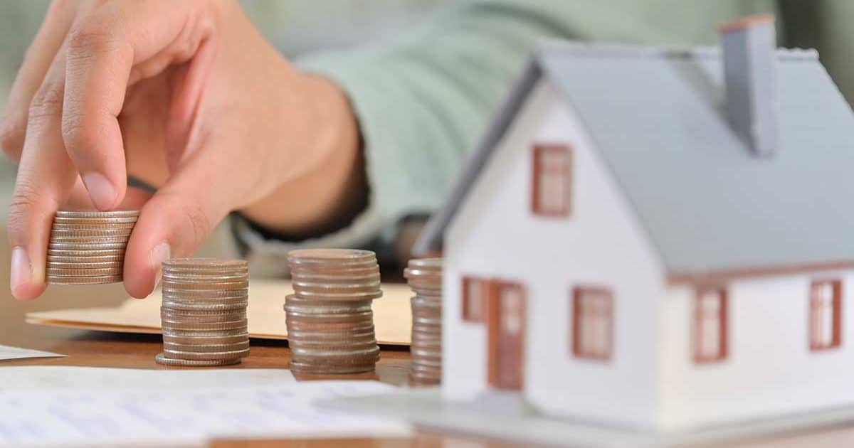 toy house and coins representing wealth