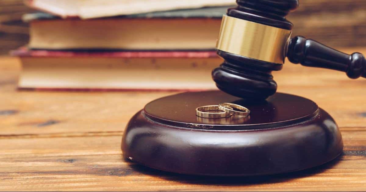 Wooden judge gavel and golden rings, divorce concept