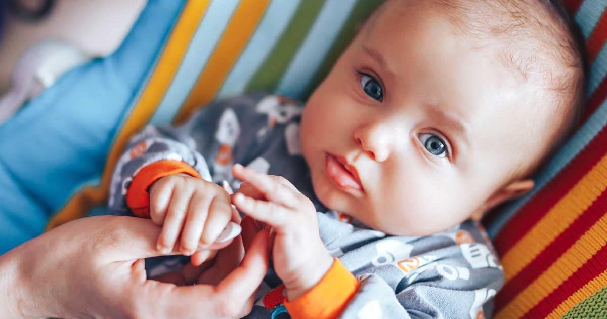 newborn baby holding parent's hand