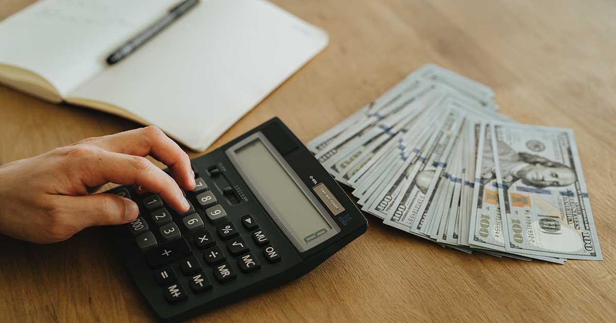 A Person using Black Desk Calculator