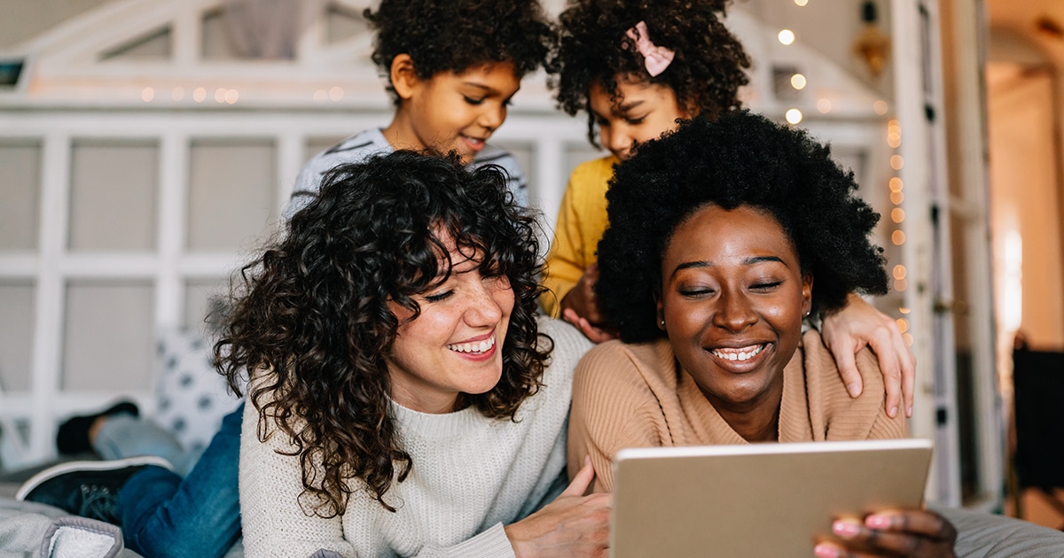 Happy lesbian multiethnic couple with childen at home. Family lgbt child happiness concept