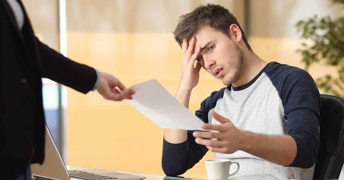 Worried man receiving a summons while sitting in his office