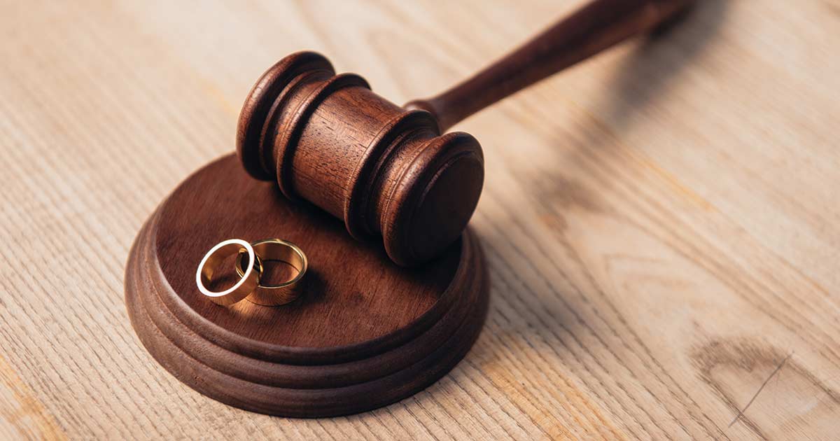 selective focus of golden rings on wooden gavel, divorce concept