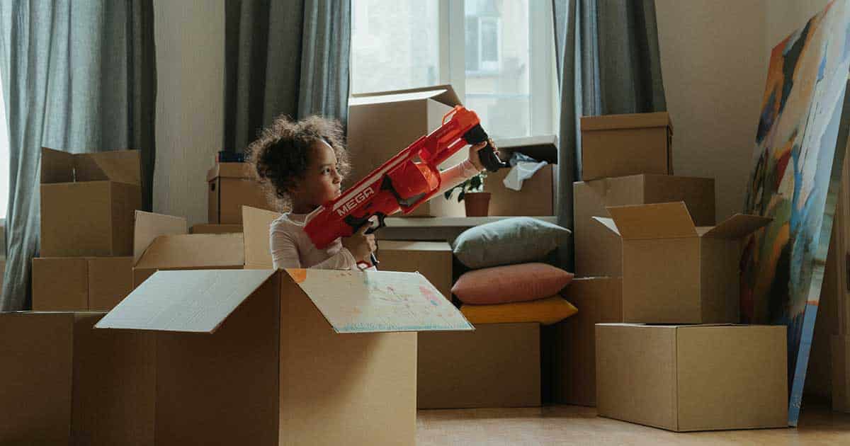 child playing in moving boxes