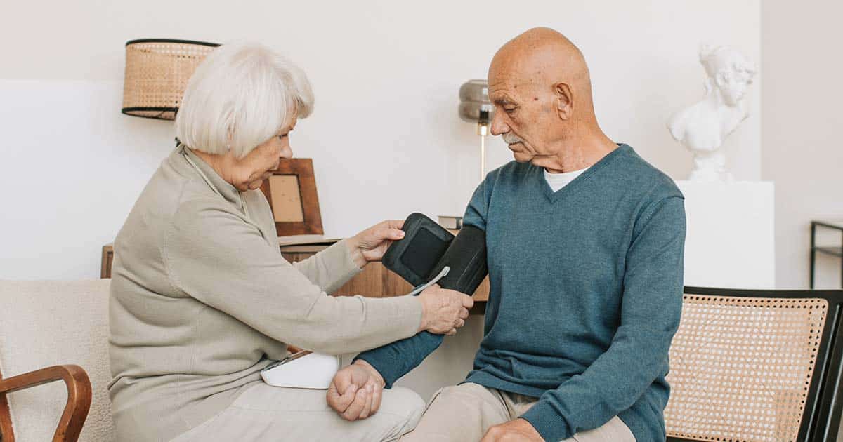 Woman taking Blood Pressure of an elderly man