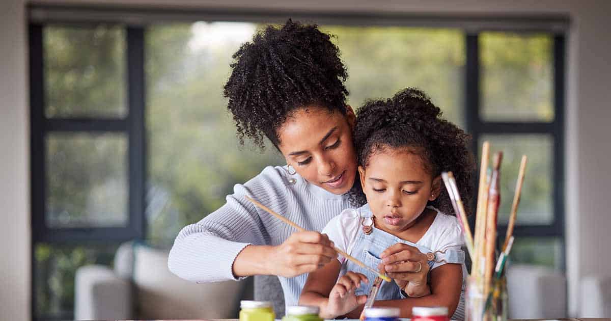 Learning, mother and child painting for an art preschool project with a young mom helping her daugh.