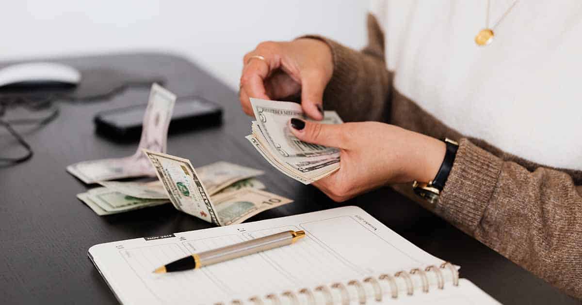 woman counting cash at her desk