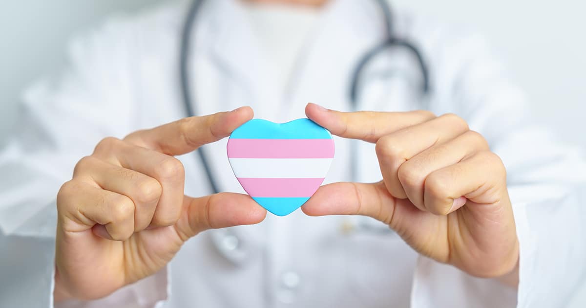 Transgender Day and LGBT pride month, LGBTQ+ or LGBTQIA+ concept. Doctor holding blue, pink and white heart shape for Lesbian, Gay, Bisexual, Transgender, Queer and Pansexual community