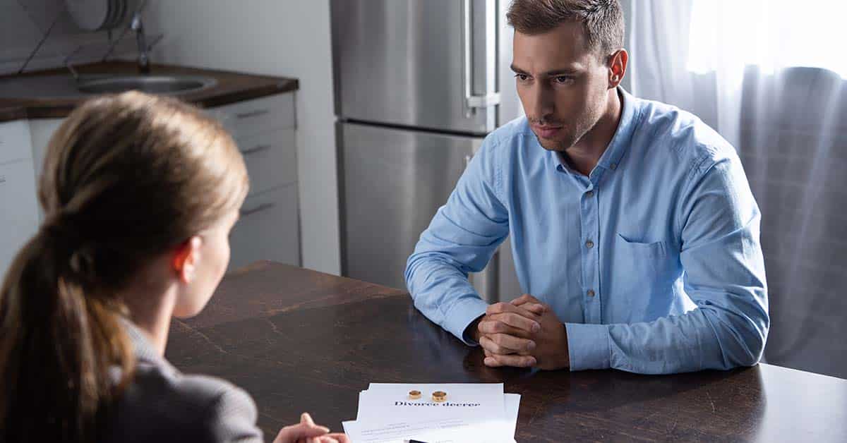 couple with divorce documents at table at home