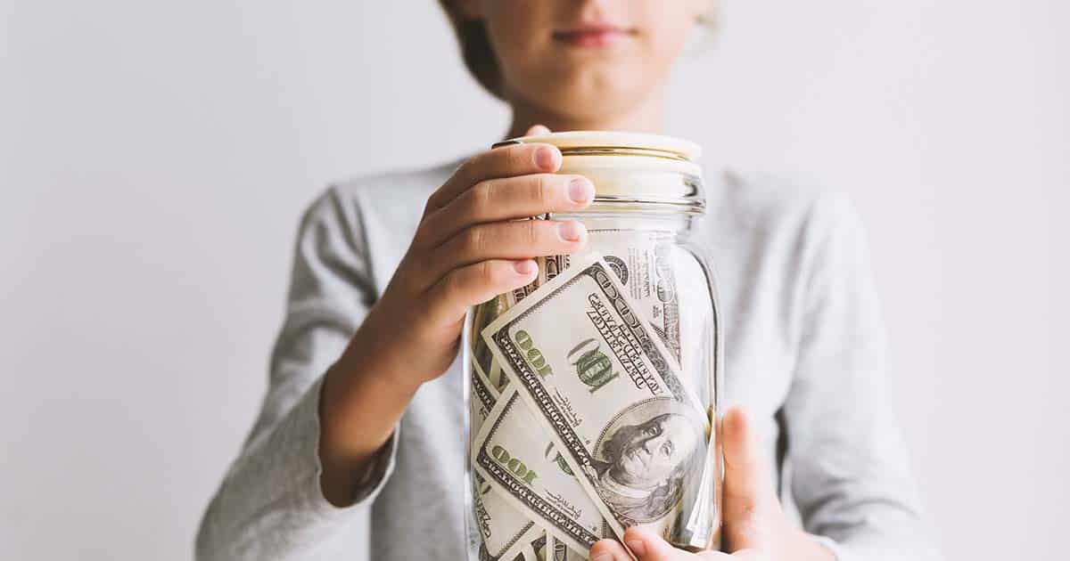 Kid holding a jar of money