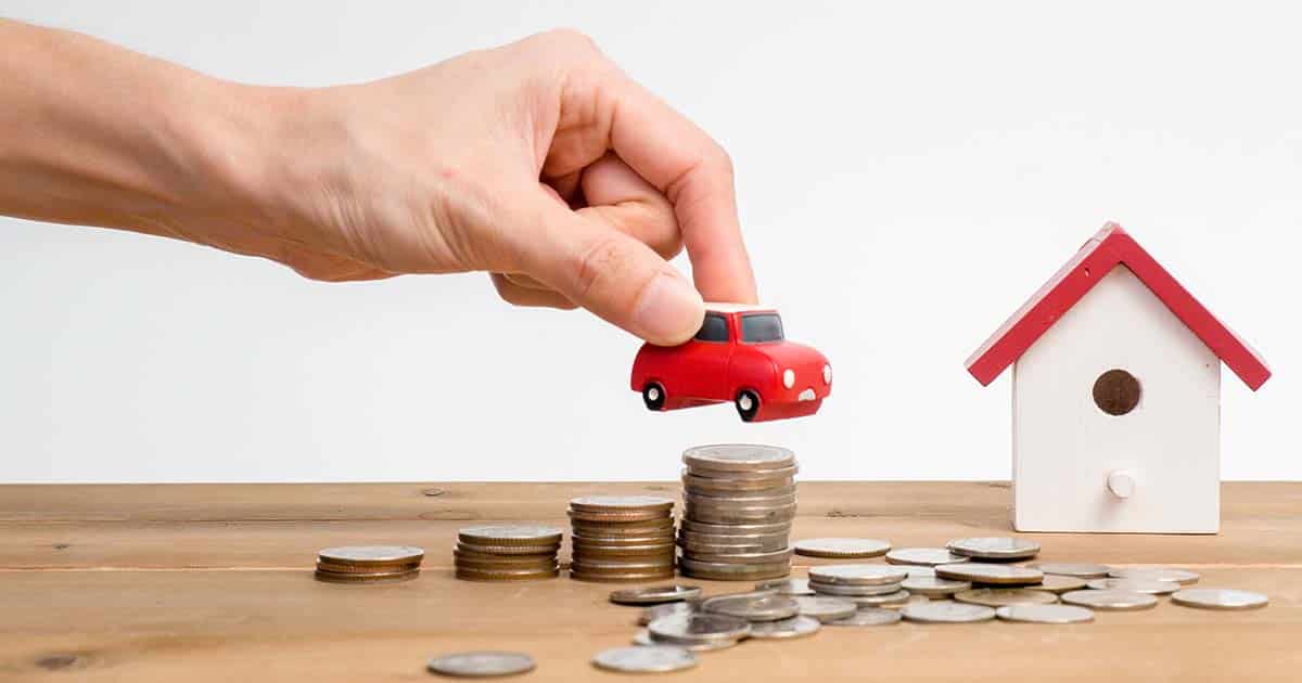 money, car and house on desk