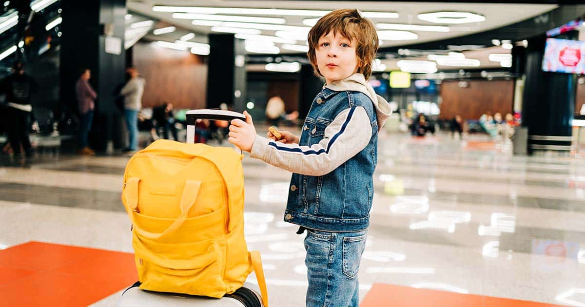 boy with suitcase and backpack in airport