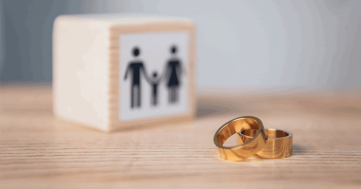 selective focus of golden rings near wooden cube with family