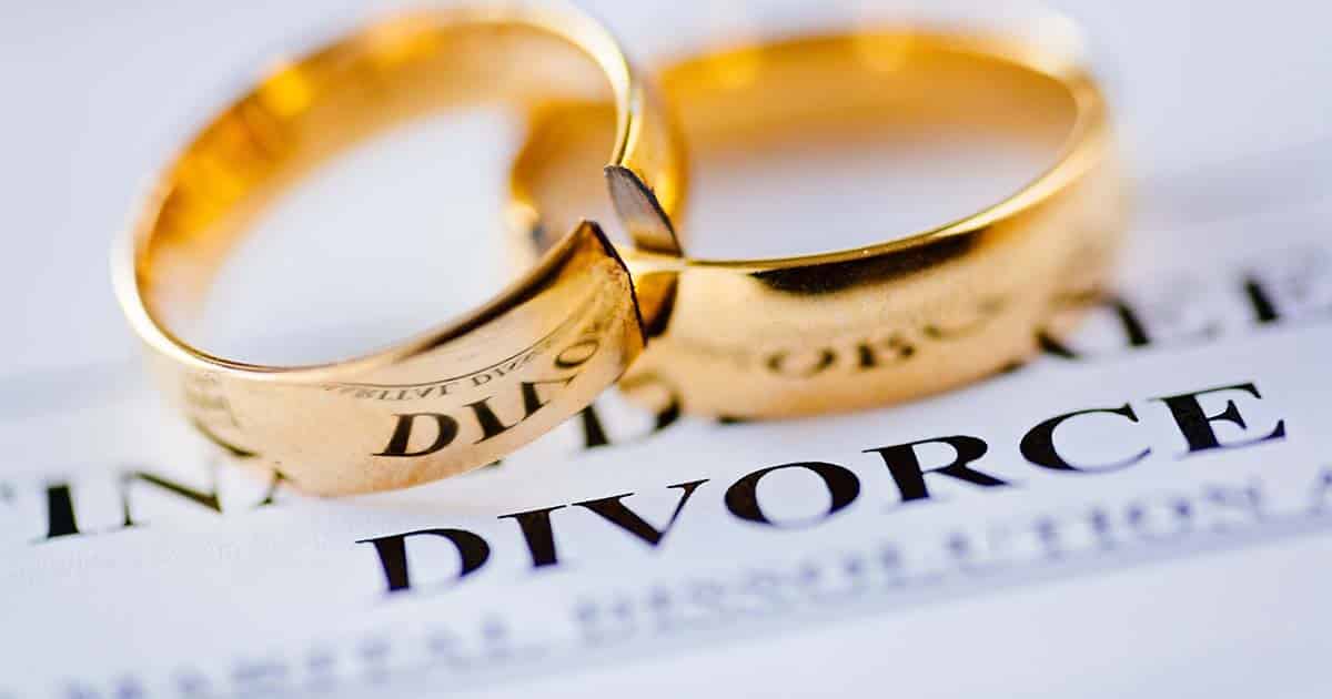 Two broken golden wedding rings divorce decree document. Divorce and separation concept