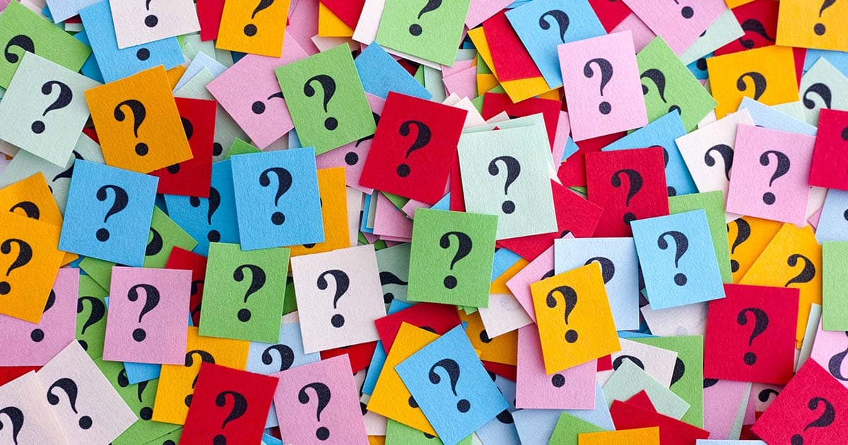 Too Many Questions. Pile of colorful paper notes with question marks. Closeup.