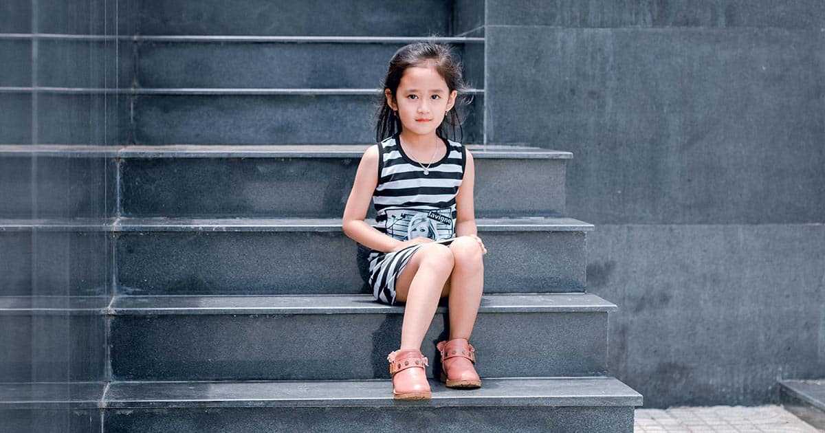 girl sitting on grey stairs